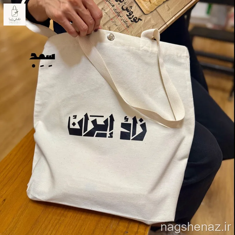 تت بگ کفی دار طرح نوشته «زادهٔ ایران» دارای جیب، کفی و دکمه فلزی