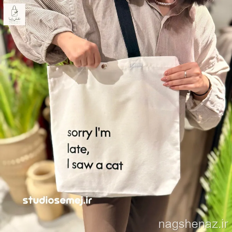تت بگ کفی دار طرح نوشته”sorry I’m late, I saw a cat “ دارای جیب، کفی و دکمه فلزی